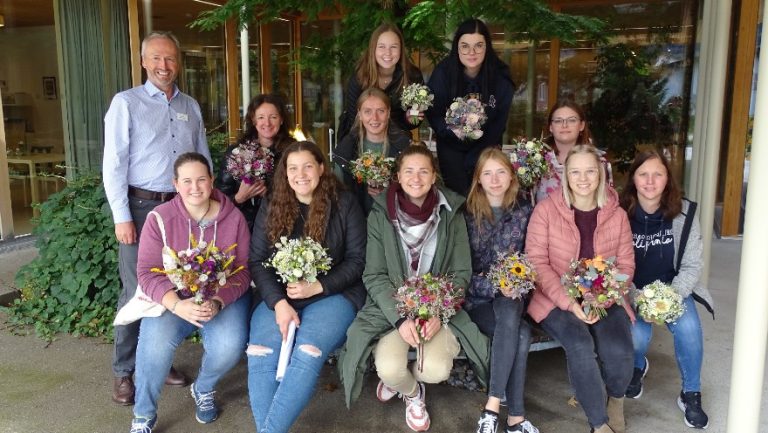 Die Schülerinnen der Tiroler Fachberufsschule für Garten, Raum und Mode und ihre Blumensträuße vor dem Hospizhaus Tirol