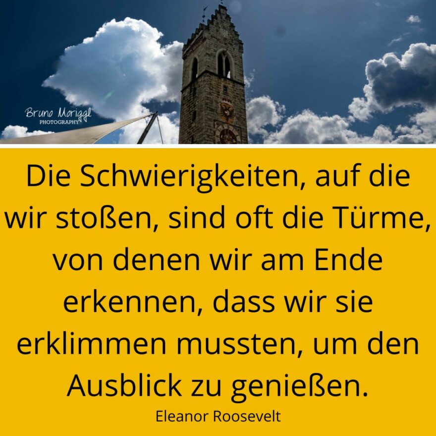 Bild eines Kirchturms mit Spruch: Die Schwierigkeiten, auf die wir stoßen, sind oft die Türme, von denen wir am Ende erkennen, dass wir sie erklimmen mussten, um den Ausblick zu genießen. Eleanor Roosevelt