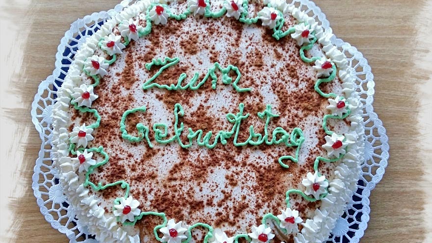 Geburstagskuchen mit einer Verzierung "Zum Geburstag"