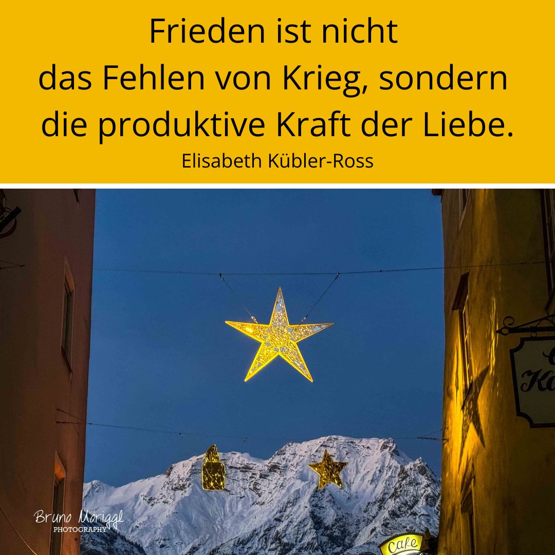 Beleuchteter Stern in Altstadt mit Spruch: Frieden ist nicht das Fehlen von Krieg, sondern die produktive Kraft der Liebe. Elisabeth Kübler-Ross