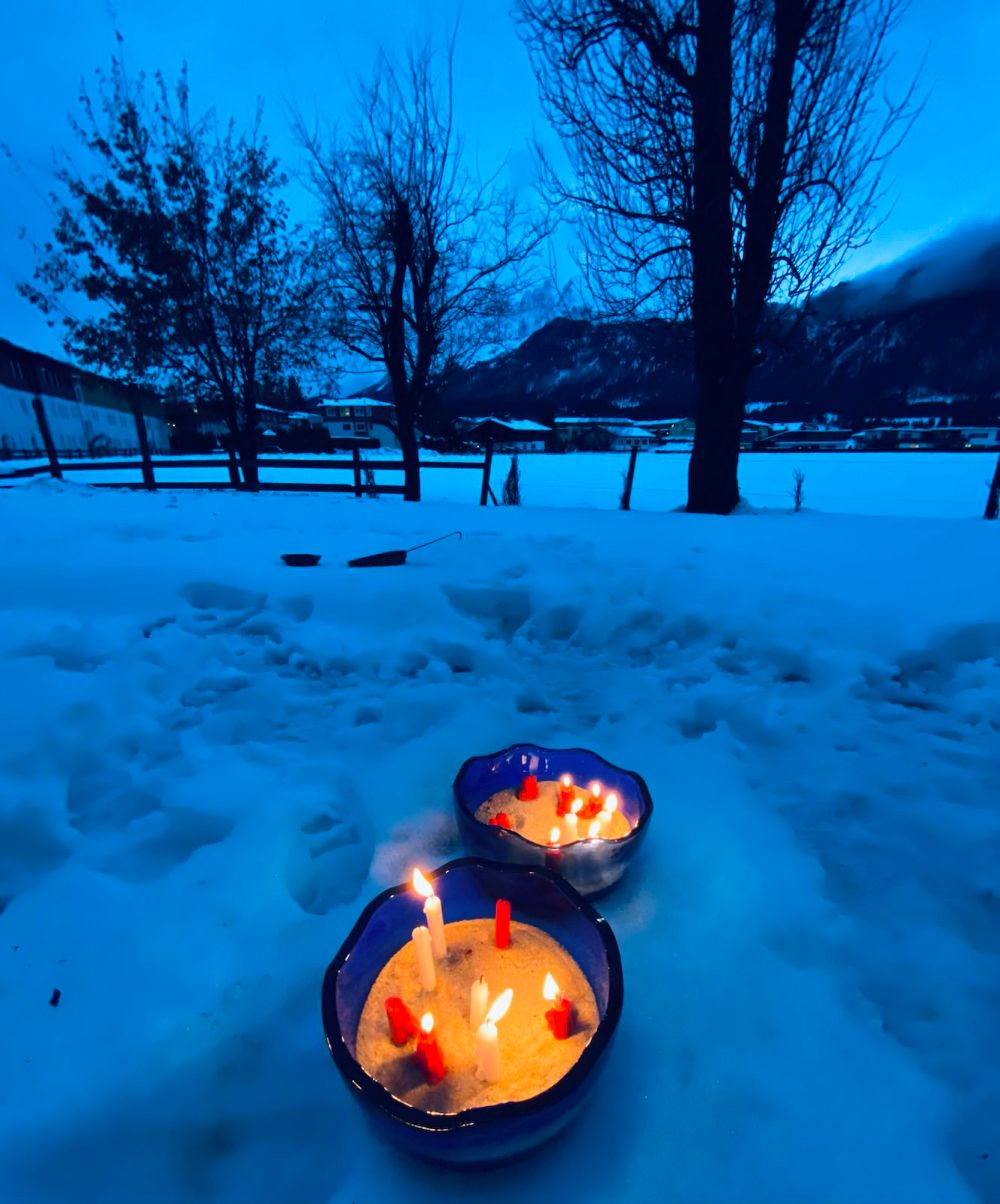 Schale mit Kerzen im Garten mit Schnee