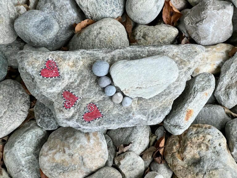 Herzen und kleiner Fuß geformt aus Steinen