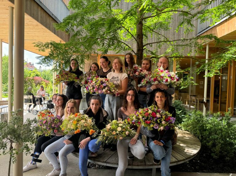 Die Schülerinnen übergeben ihre Blumensträuße
