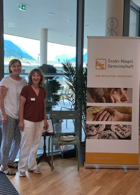 2 Teammitglieder mit Hospiz Aufsteller