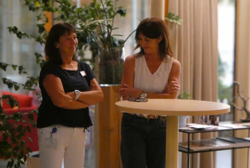 Romana Tomac und Monika Wibmer stehen bei einem Stehtisch im Hospizcafe