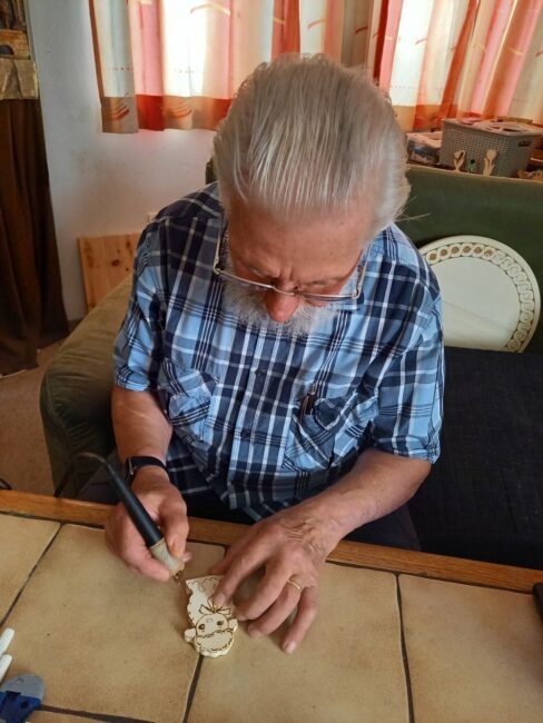 Herr Sonnweber beim Bemalen eines Holztiers