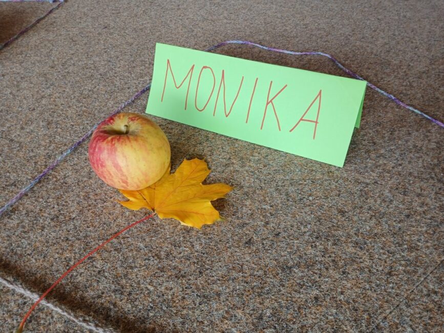 Ein Apfel und ein Namensschild auf dem Monika steht