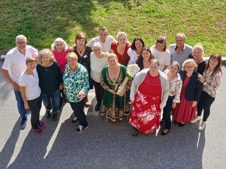Gruppenbild der Ehrenamtlichen die nach oben schauen. Foto wurde vom Balkon aus gemacht.