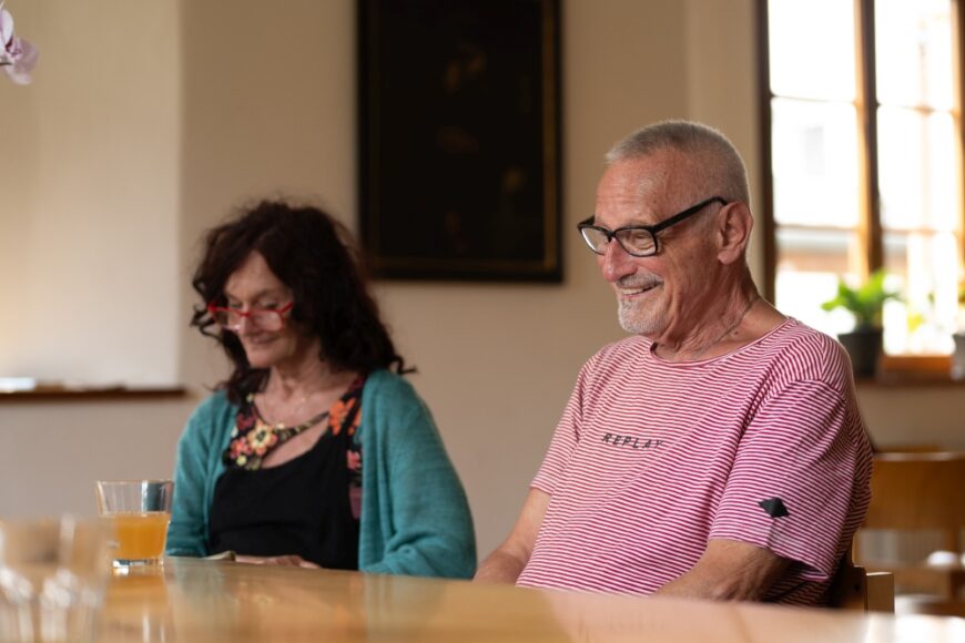 Ein lachender Konstantin Wecker sitzt neben Elisabeth Draxl