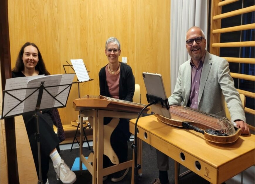 Die Mitglieder der Familie Beisler sitzen hinter den Instrumenen und lachen in die Kamera.