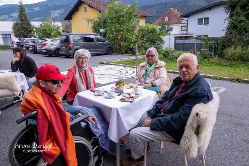 Besucher*innen am Tisch vor dem Hospizhaus