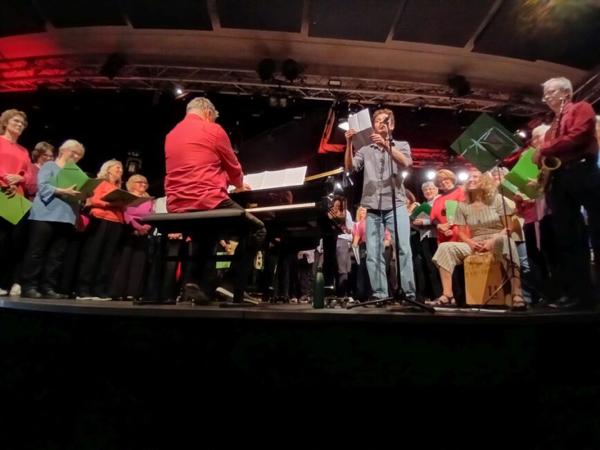 Emil Kaschka beim Slamen, neben ihm spielt Bernhard Sieberer Klavier