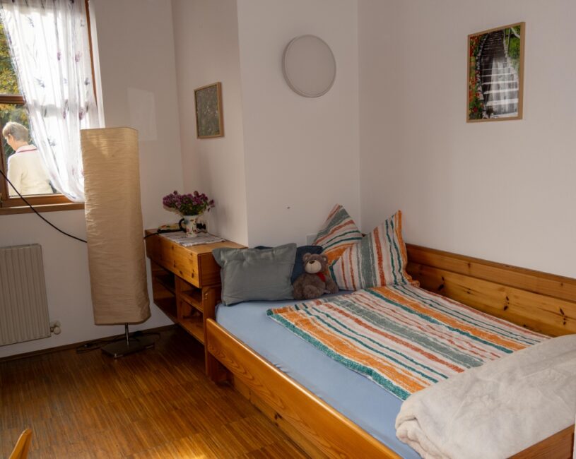 Das Krankenzimmer - im Bild ein Bett mit bunter Bettwäsche