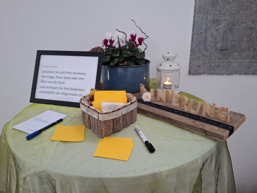 Tisch Klagemauer mit brennender Kerze und Möglichkeit zum Aufschreiben der Klage