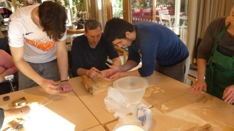 Ein Patient des Tageshospizes und zwei Kinder stechen Kekse aus