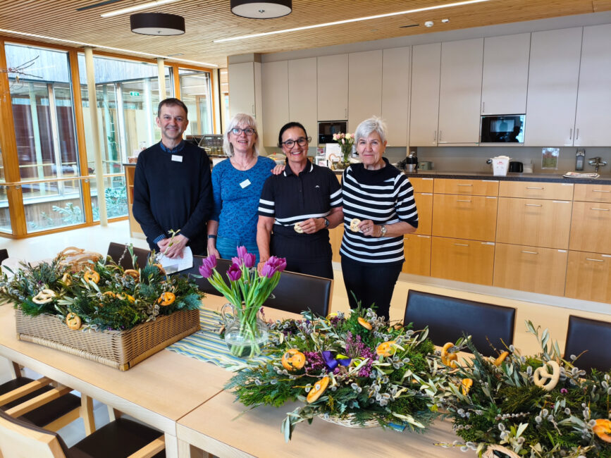 Seelsorge und ehrenamtliche Mitarbeiterinnen mit Palmbuschen