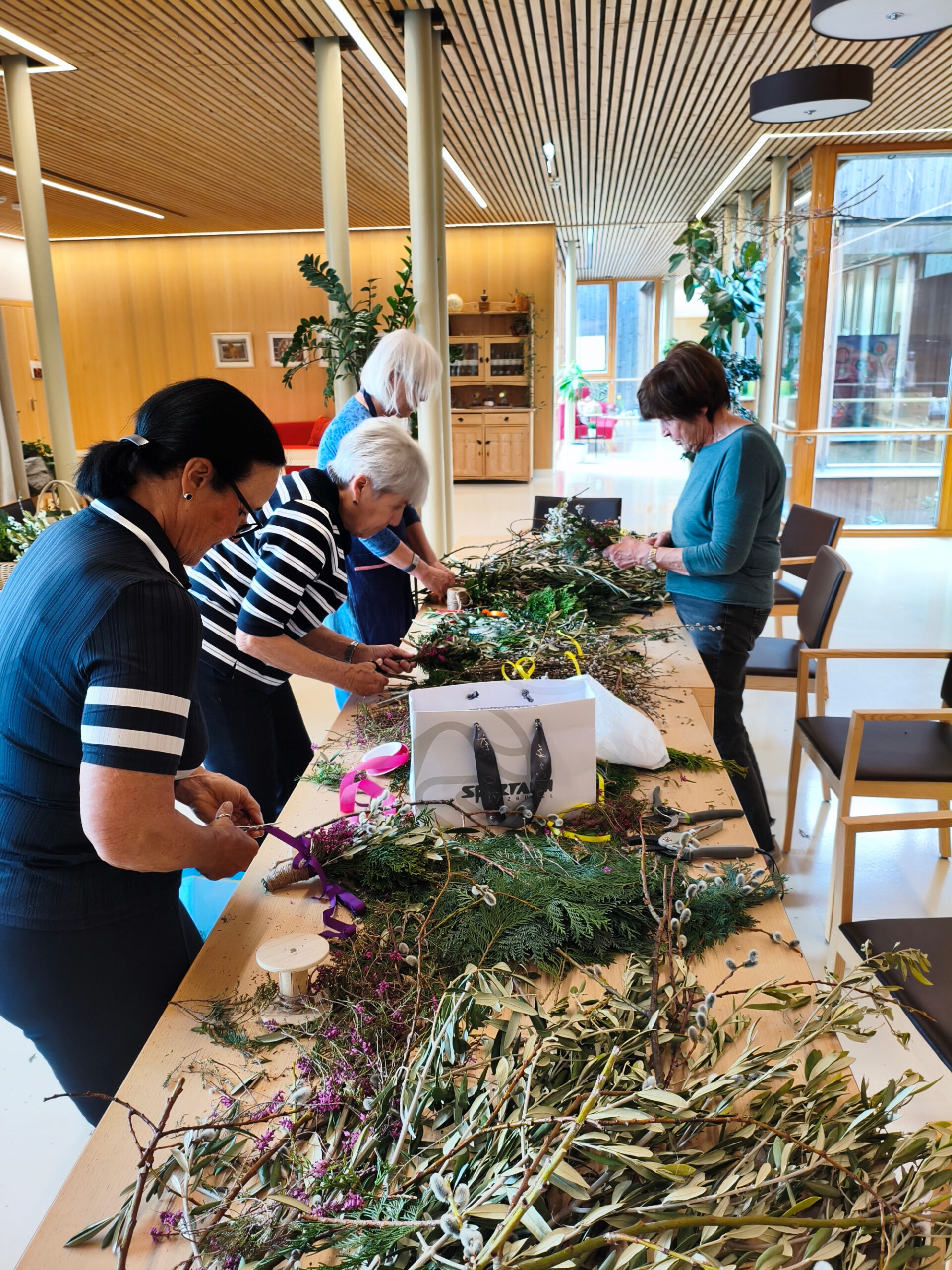 Mitarbeiterinnen und Angehörige beim Palmbusch-binden