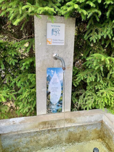 Brunnen mit Logo Tiroler Hospiz-Gemeinschaft