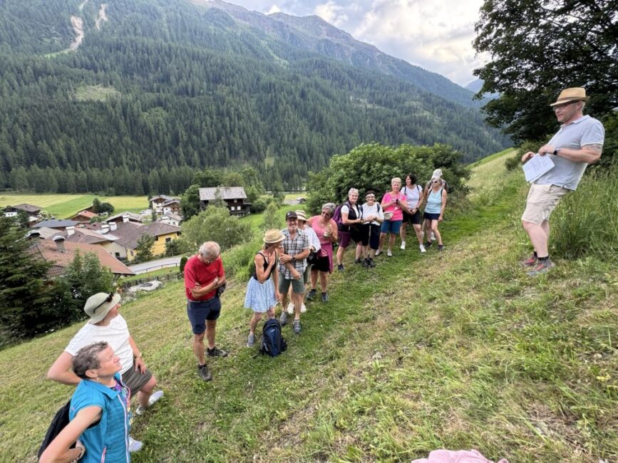 Auf der Sonnenseite des Hügels steht die Wandergruppe