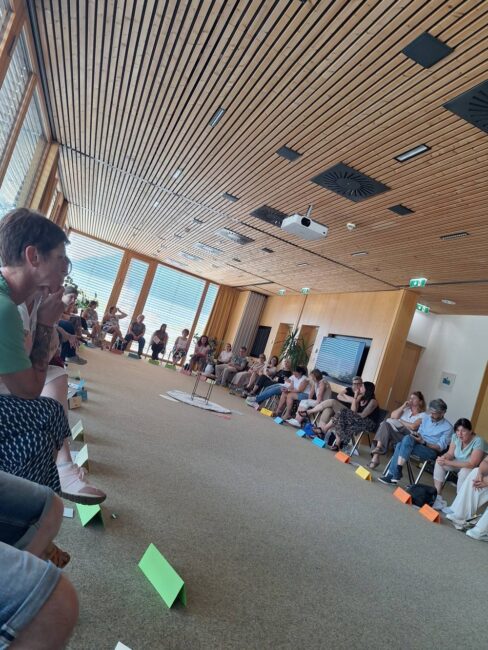 Die Teilnehmer*innen sitzen im Kreis im großen Saal der Akademie im Hospizhaus