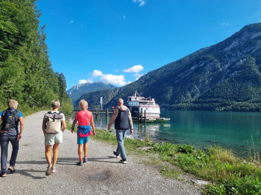 Ehrenamtliche wandern am Ufer des Achensees